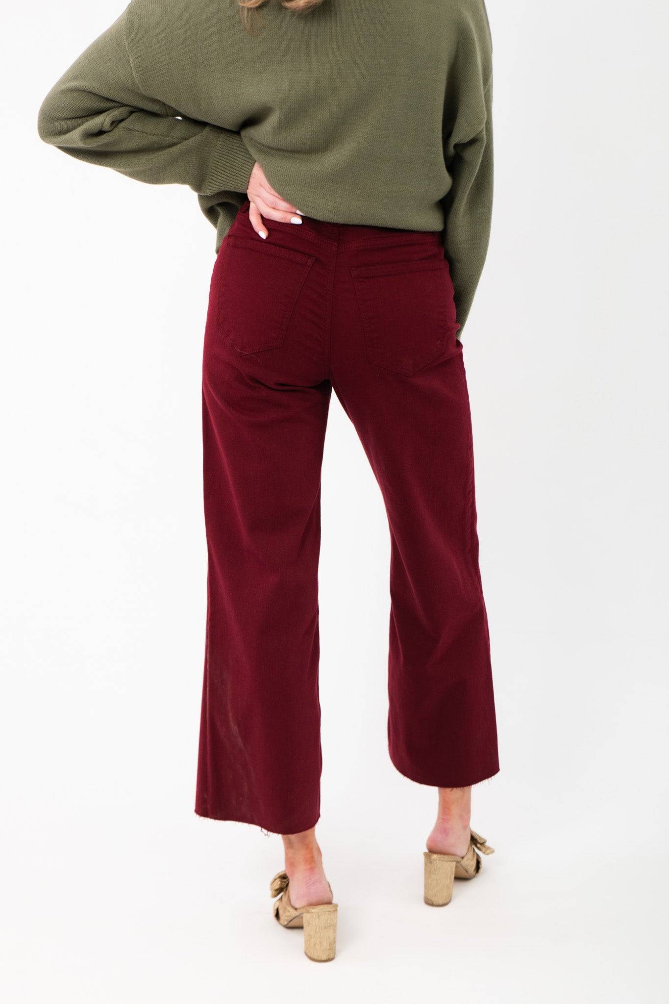 Back view of Kut Maroon Meg High Rise Jeans highlighting rear pockets and wide leg cut. Frayed hem adds a trendy touch to festive denim.