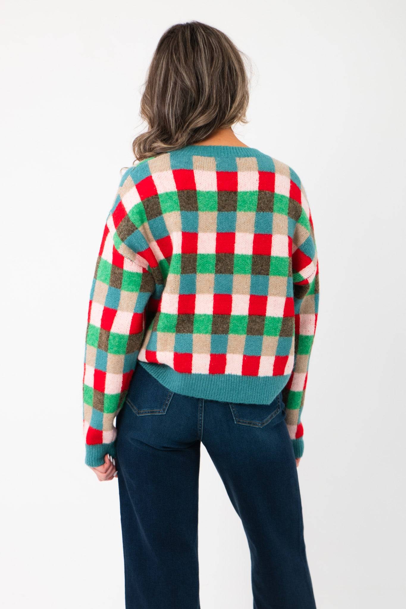 Back view of the Holiday Check Knit Sweater featuring a vibrant blue, red, and green check design with ribbed hem and cuffs.