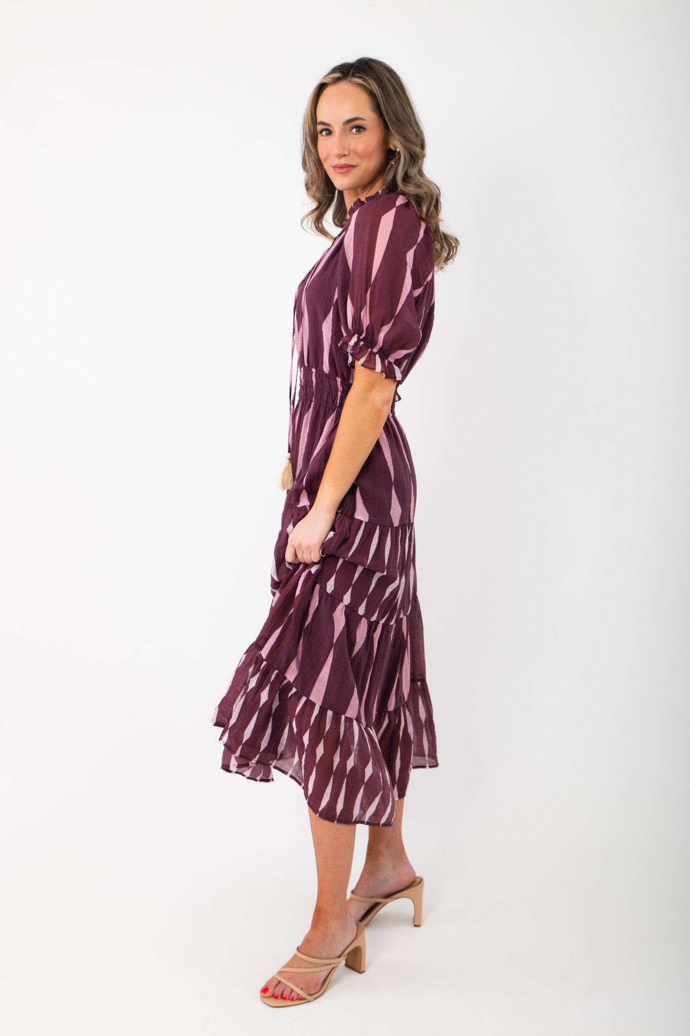 Side view of THML Burgundy & Pink Pattern Maxi Dress showing puff sleeves and flared tiered hem, perfect for stylish seasonal outfits.