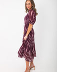 Side view of THML Burgundy & Pink Pattern Maxi Dress showing puff sleeves and flared tiered hem, perfect for stylish seasonal outfits.