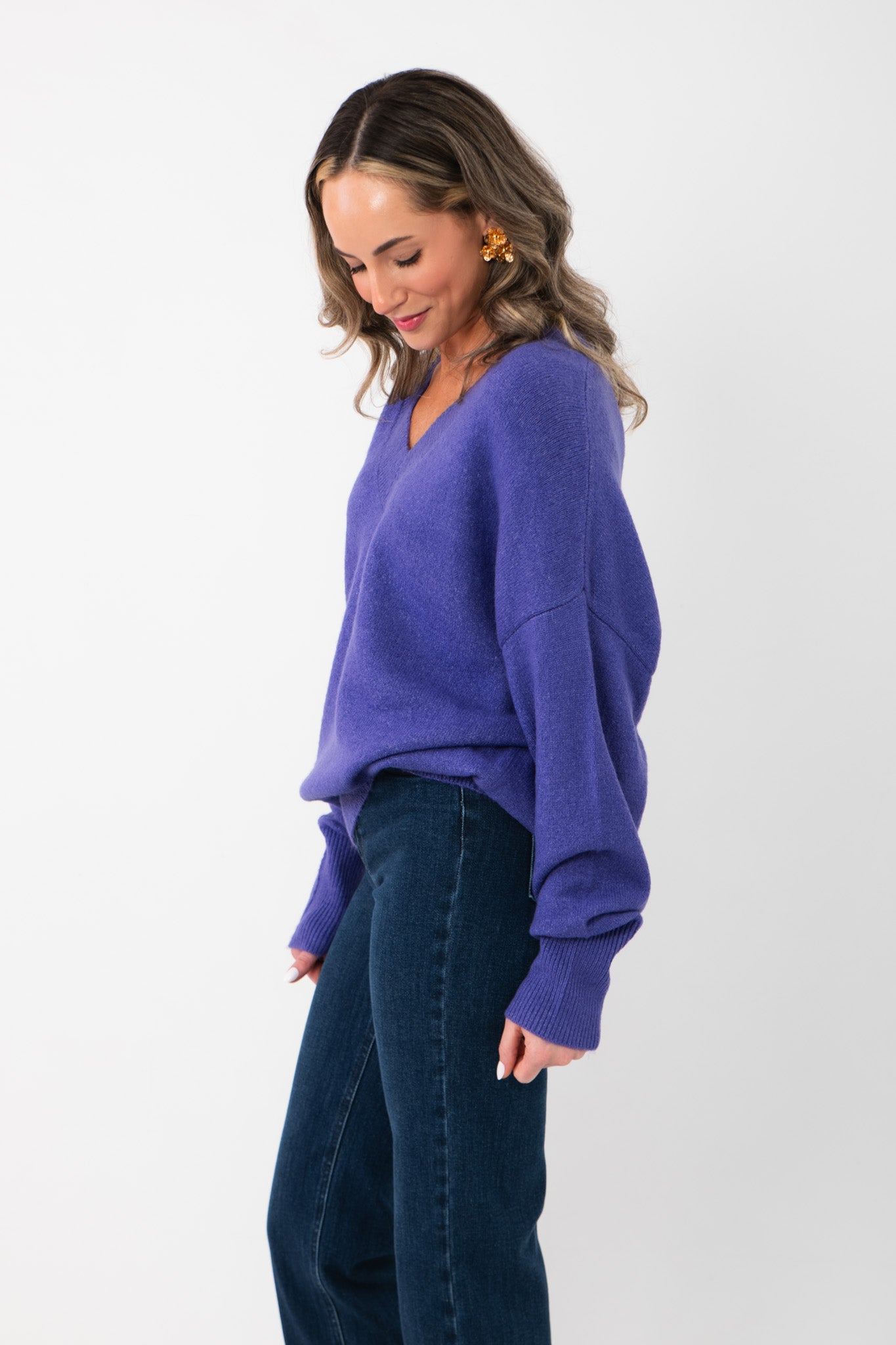 Side view of Olivia Oversized Purple V‑Neck Sweater showing dropped shoulders and loose fit, ideal for gameday or casual wear.