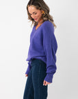 Side view of Olivia Oversized Purple V‑Neck Sweater showing dropped shoulders and loose fit, ideal for gameday or casual wear.