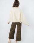 Laura Ivory Pearl Cardigan – Back view of elegant ivory cardigan with ribbed hem and dropped shoulders, styled for casual chic.