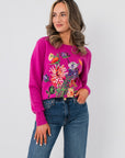 Bloom Again Floral Magenta Sweater – Cozy crew neck knit with vibrant floral embroidery, styled with blue jeans for a casual spring look.