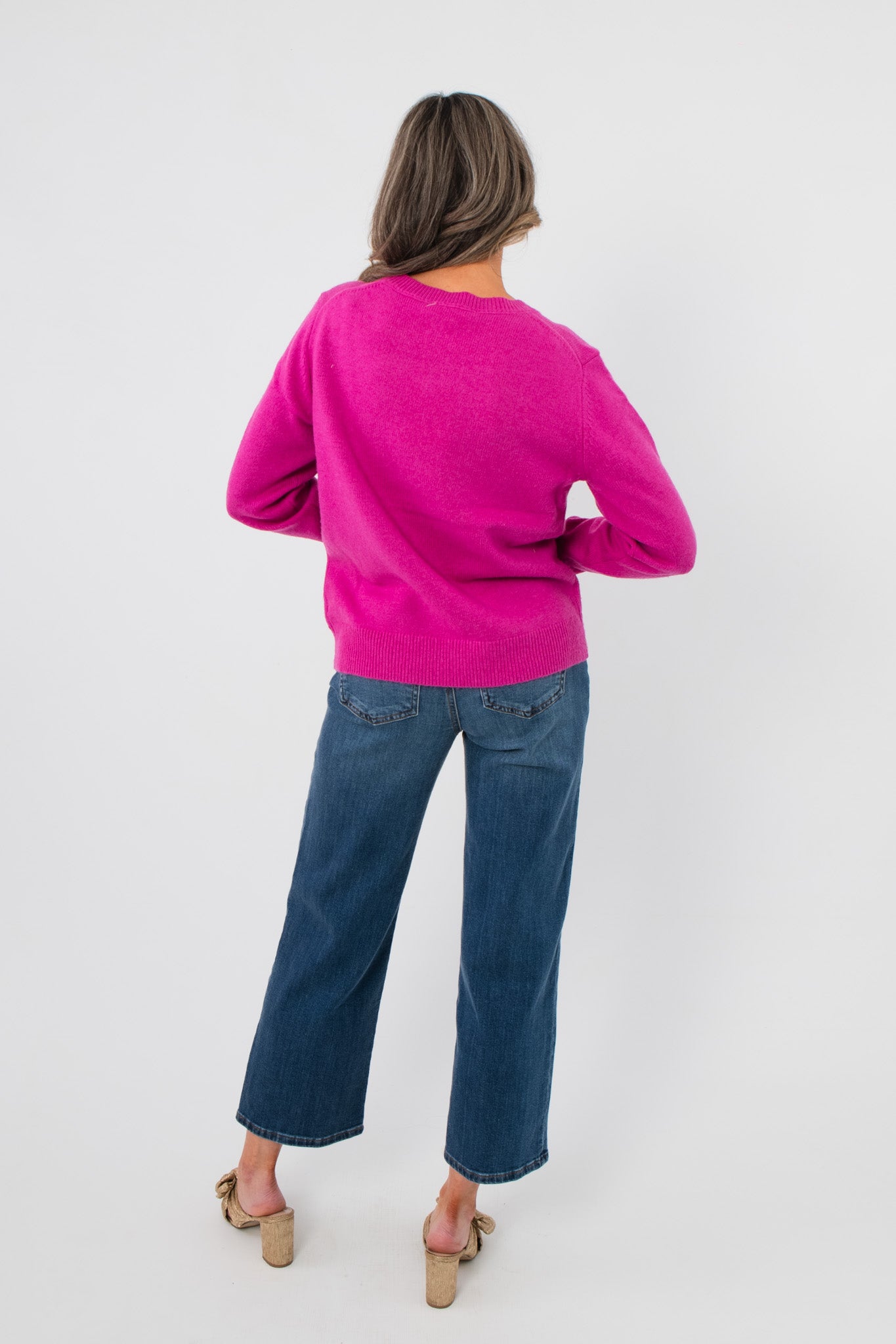 Back view of Bloom Again Floral Magenta Sweater highlighting solid magenta knit and ribbed hem, ideal for spring layering in casual outfits.