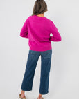 Back view of Bloom Again Floral Magenta Sweater highlighting solid magenta knit and ribbed hem, ideal for spring layering in casual outfits.