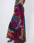 Side view of Neon Prowl Animal Print Silky Skirt showcasing its fluid drape and vivid cheetah print in neon hues on silky fabric.