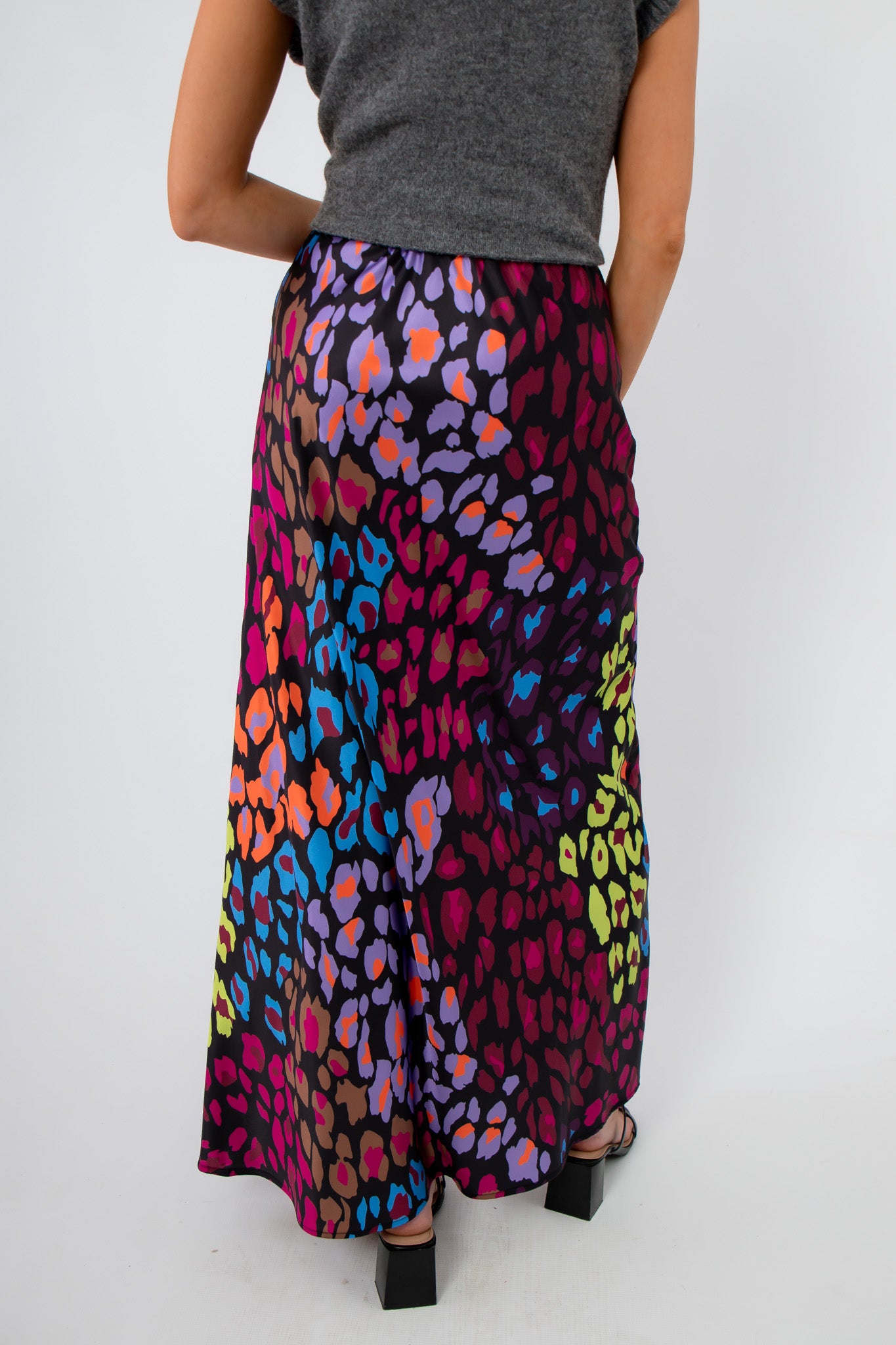 Back view of Neon Prowl Animal Print Silky Skirt highlighting the smooth fit and colorful animal print design on a maxi silhouette.
