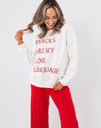 Snacks Are My Love Language Sweatshirt – White graphic pullover with red text, styled with red pants for a cozy Valentine's look.