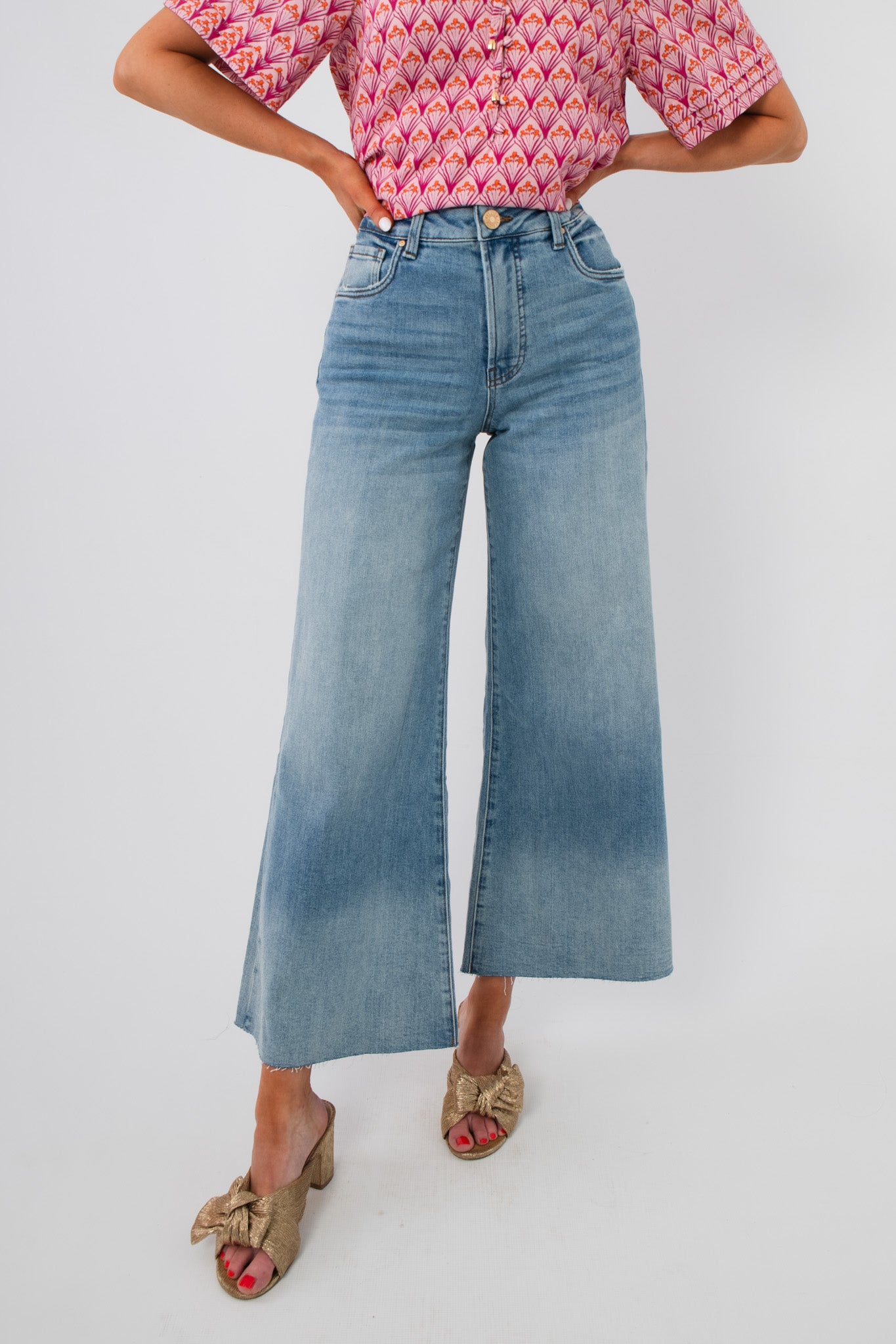 Kut Generosity Ryan High Rise Super Wide Leg Jean in light wash with raw hem and tummy-smoothing fit, styled with a pink patterned top.