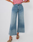Kut Generosity Ryan High Rise Super Wide Leg Jean in light wash with raw hem and tummy-smoothing fit, styled with a pink patterned top.