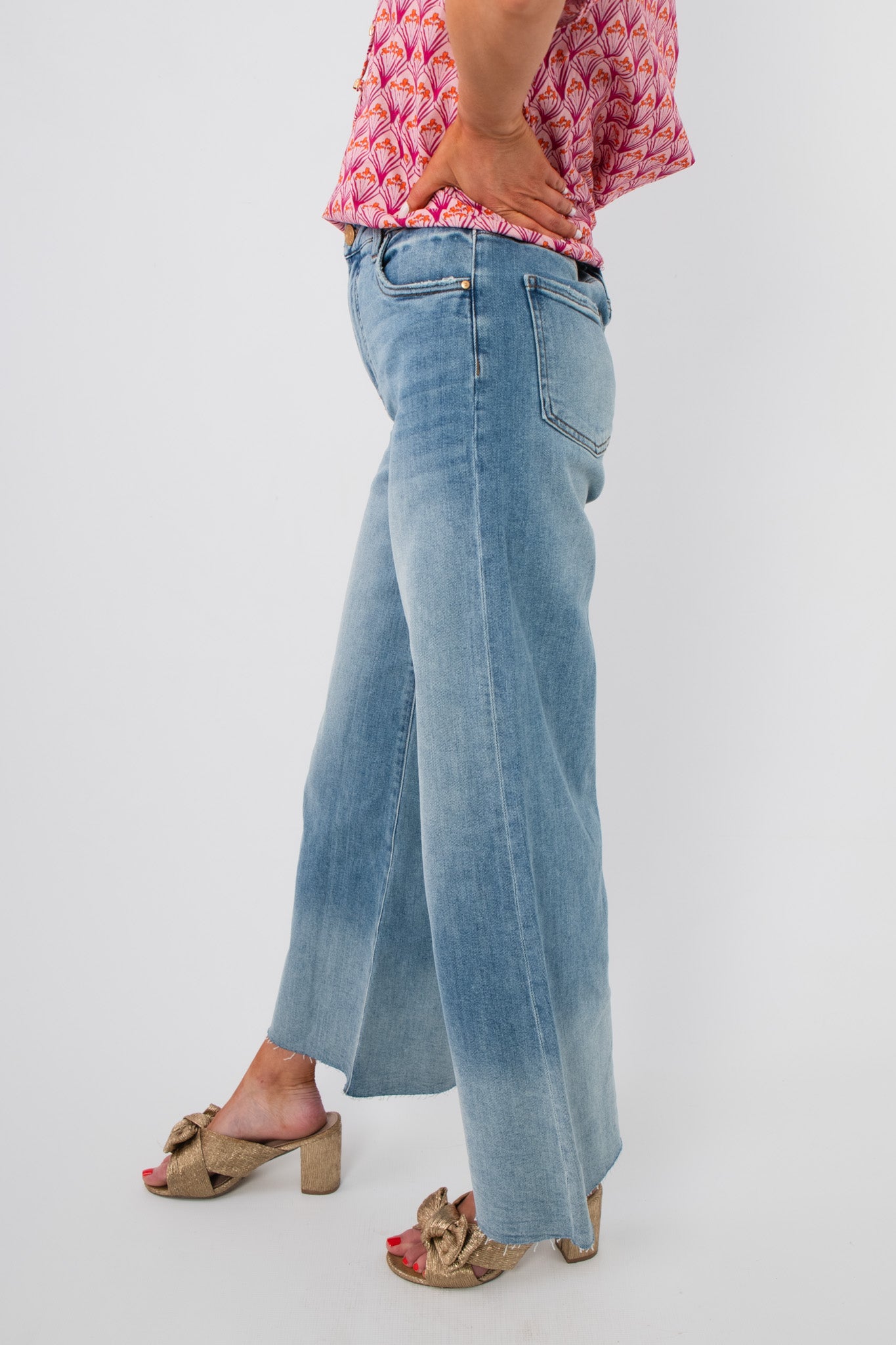 Side view of Kut Generosity Ryan High Rise Super Wide Leg Jean showing wide leg silhouette and raw hem in a soft light wash denim.