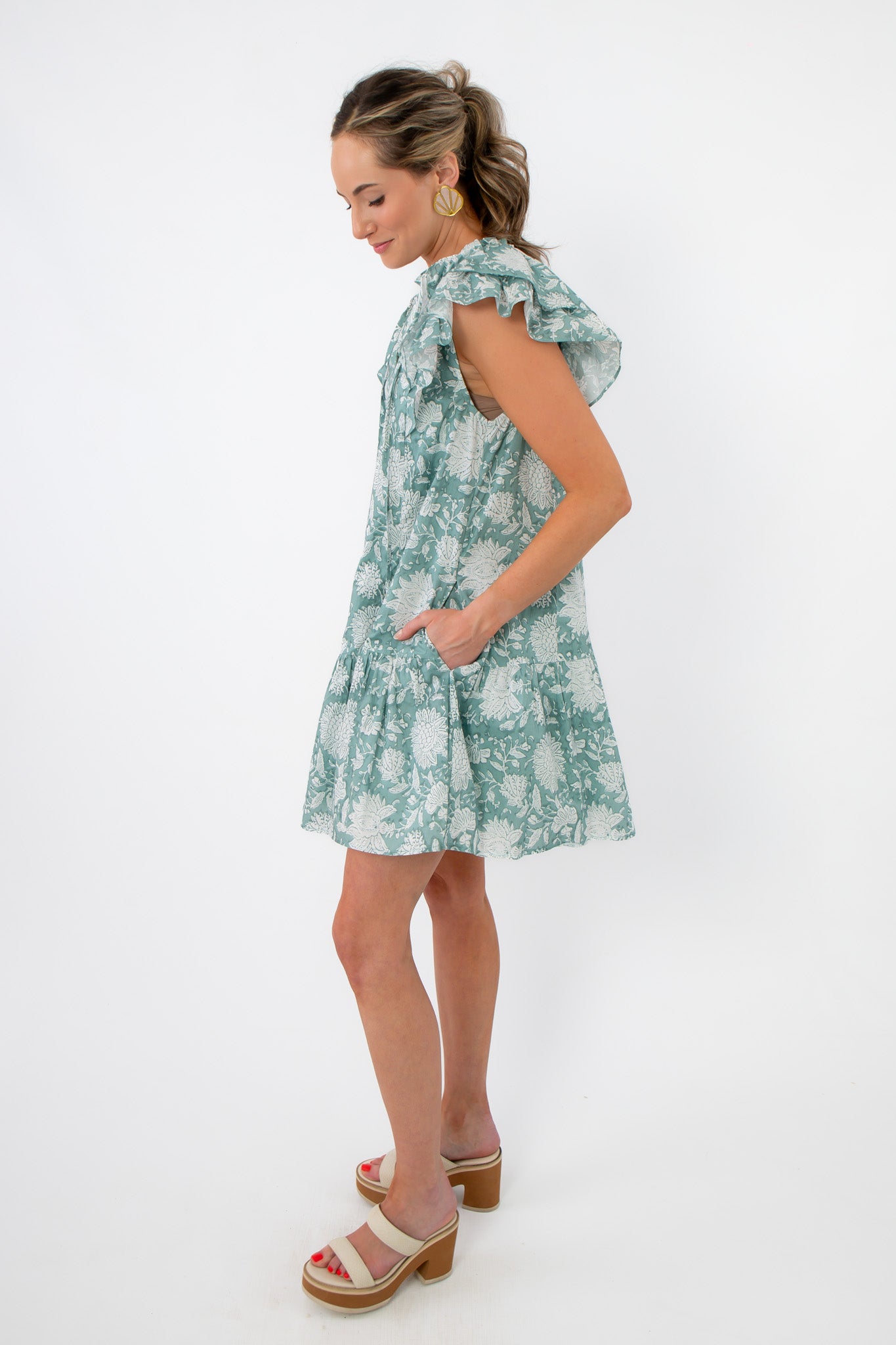 Side view of Sullivan Seafoam Garden Bloom Ruffle Dress featuring ruffled sleeves and convenient side pockets for everyday comfort.