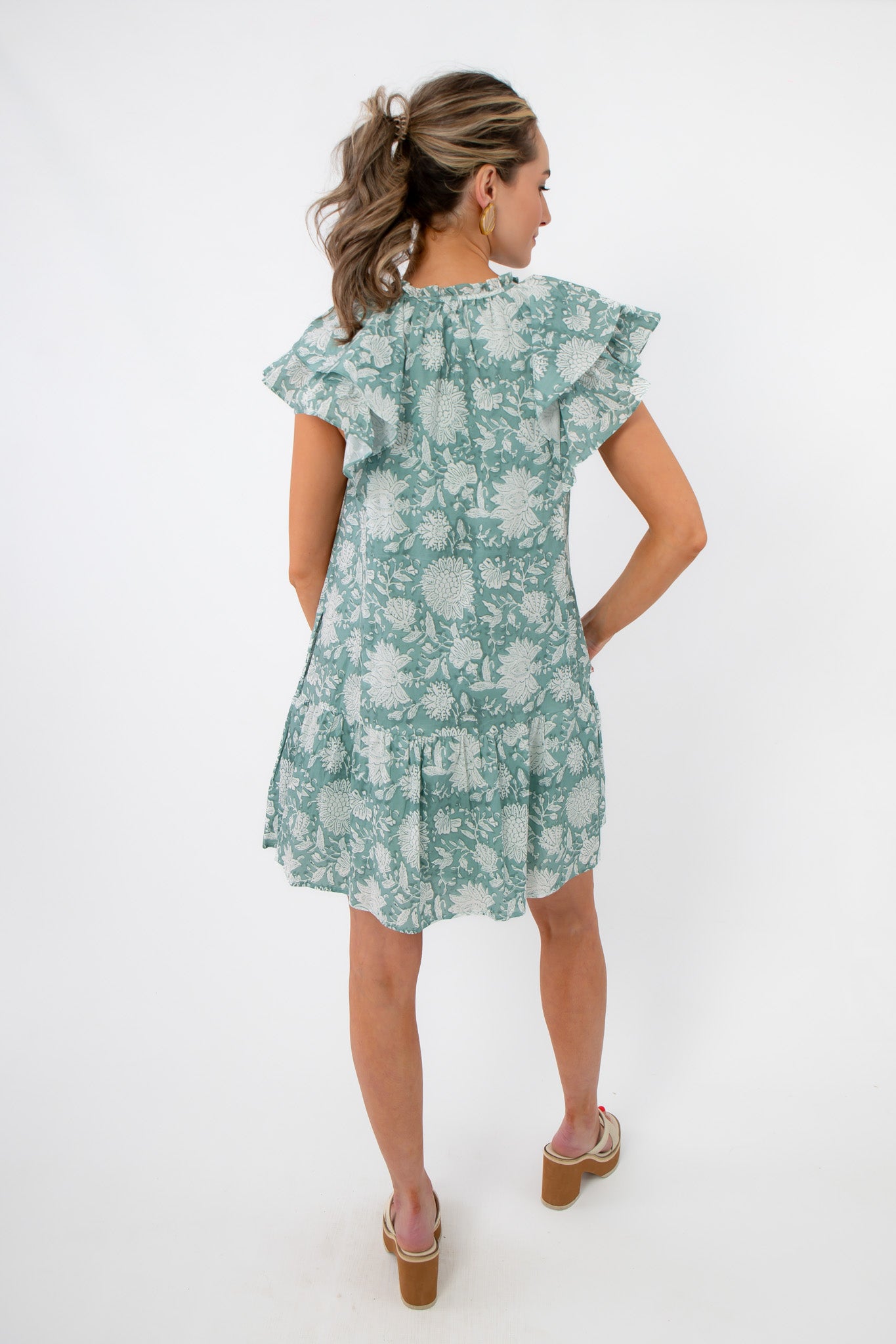 Back view of Sullivan Seafoam Garden Bloom Ruffle Dress showing tiered hem and relaxed fit, great for casual floral fashion.