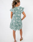 Back view of Sullivan Seafoam Garden Bloom Ruffle Dress showing tiered hem and relaxed fit, great for casual floral fashion.