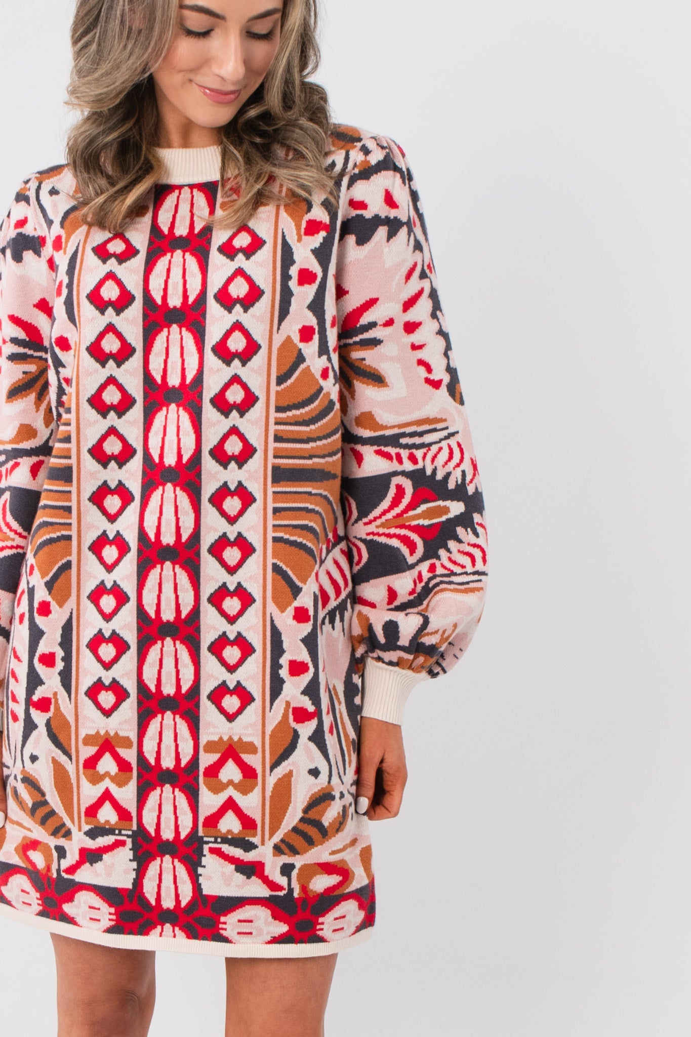 Close-up of Cathy Pink Jacquard Knit Mini Dress showcasing textured pink jacquard knit and intricate red and tan pattern details on the front.