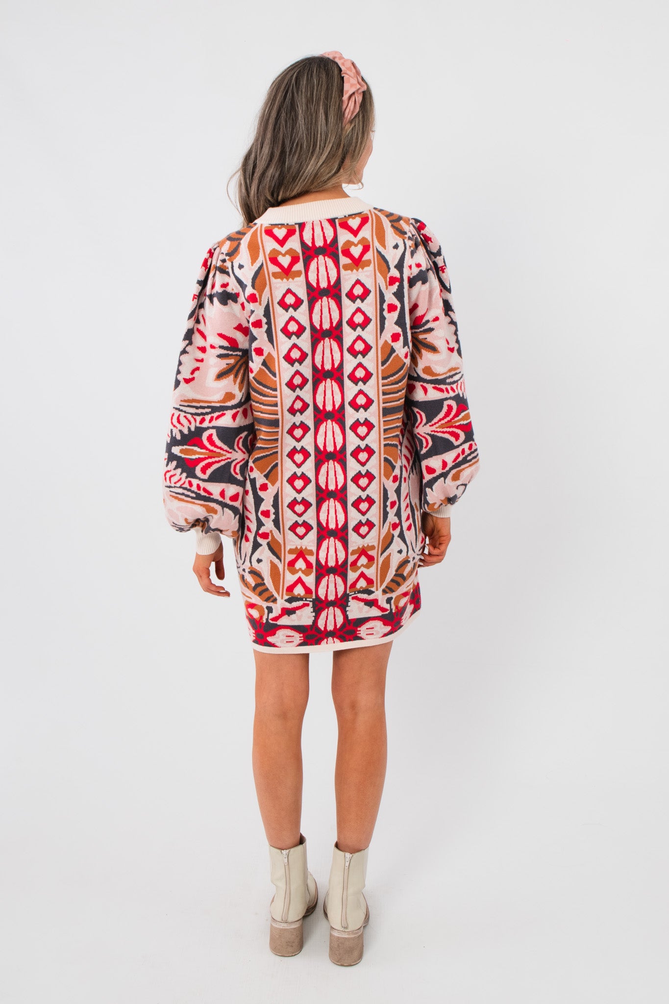 Back view of Cathy Pink Jacquard Knit Mini Dress featuring symmetrical jacquard patterns and voluminous sleeves for a cozy, stylish finish.
