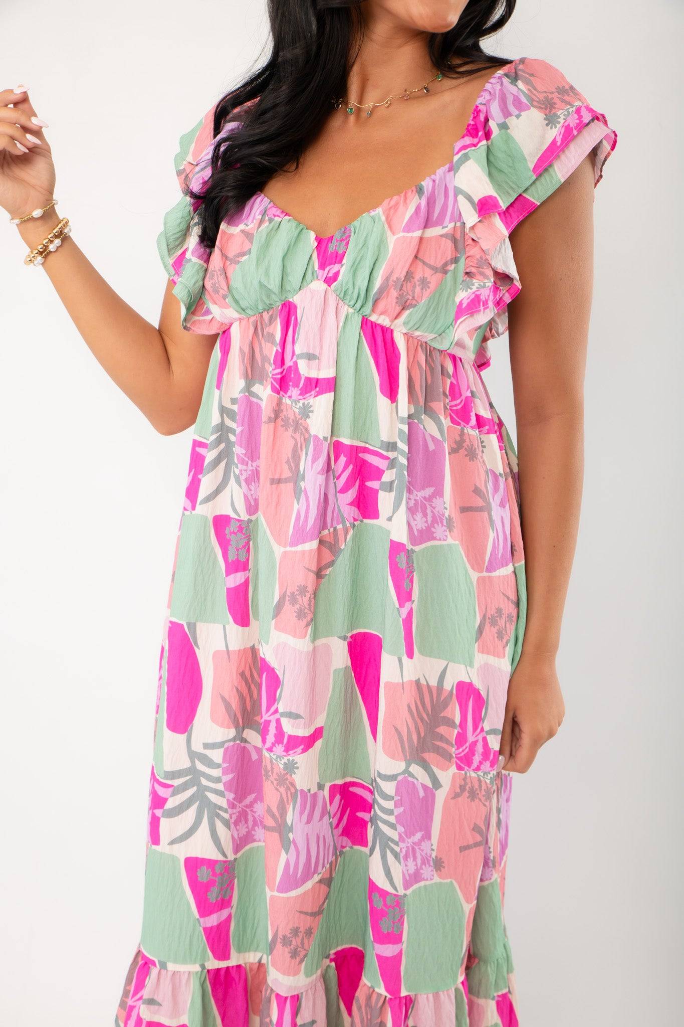 Close-up of THML Pink Palm Ruffle Sleeve Maxi Dress highlighting ruffle sleeves, empire waist, and bold pink and green tropical pattern.