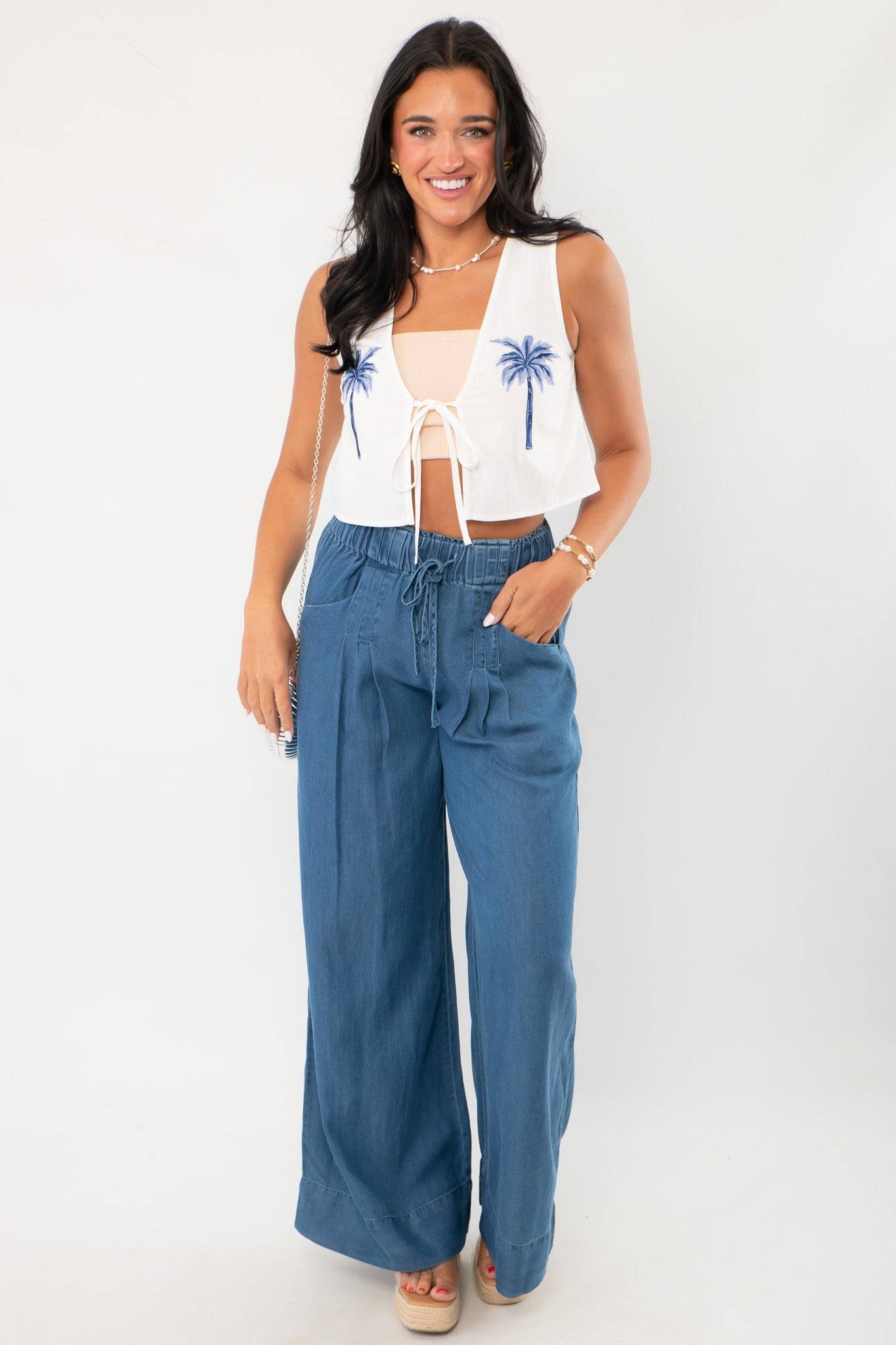 Versatile Dark Wash Denim Wide Leg Drawstring Pants styled with a sleeveless crop top, featuring a relaxed fit and elastic waistband for comfort.