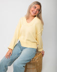 Casual seated pose in Lemon Sorbet Scoop Neck Sweater, showcasing its soft knit texture and cozy oversized silhouette for spring fashion.