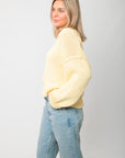 Side profile of Lemon Sorbet Scoop Neck Sweater – loose fit and dropped shoulders in a pastel yellow knit, styled with denim.