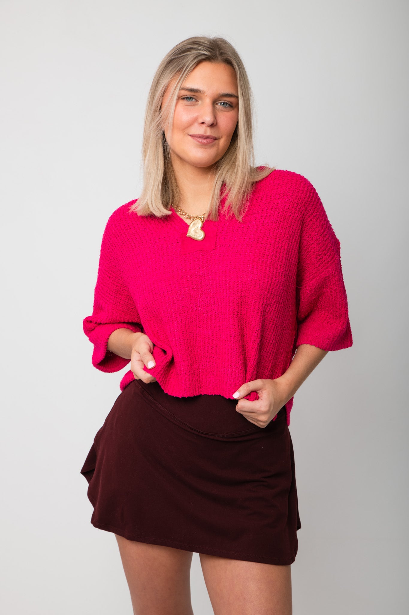 Fuchsia Short Sleeve Crop Sweater – Oversized pink v-neck top with boxy fit, styled with a dark mini skirt for a bold casual look.