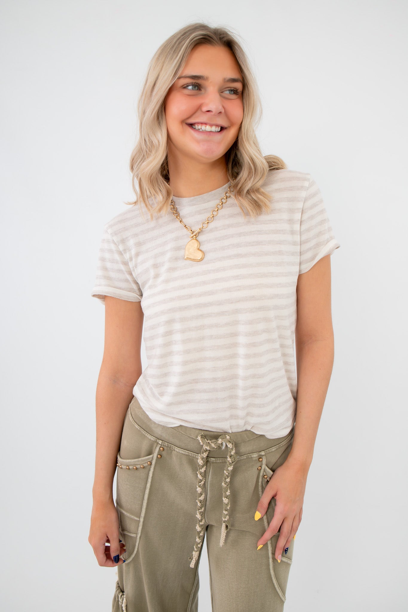 Z Supply Natural Heather Tourist Striped Tee in beige and cream with short sleeves, styled casually with olive drawstring pants.
