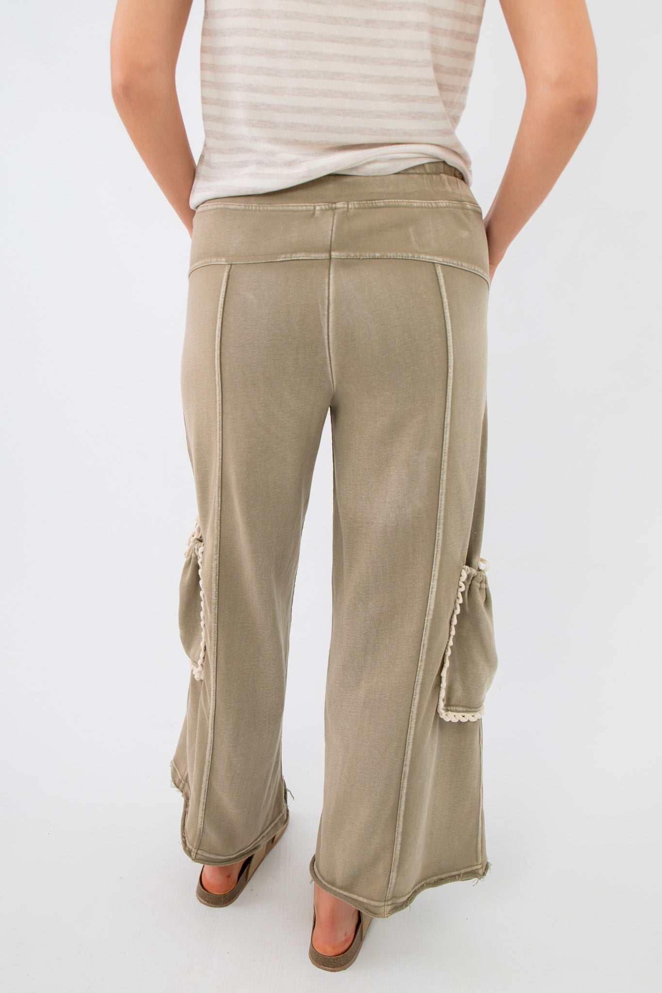 Back view of Smokey Sage Cactus Blossom wide leg pants with exposed seams and dual side pouch accents for a relaxed bohemian look.