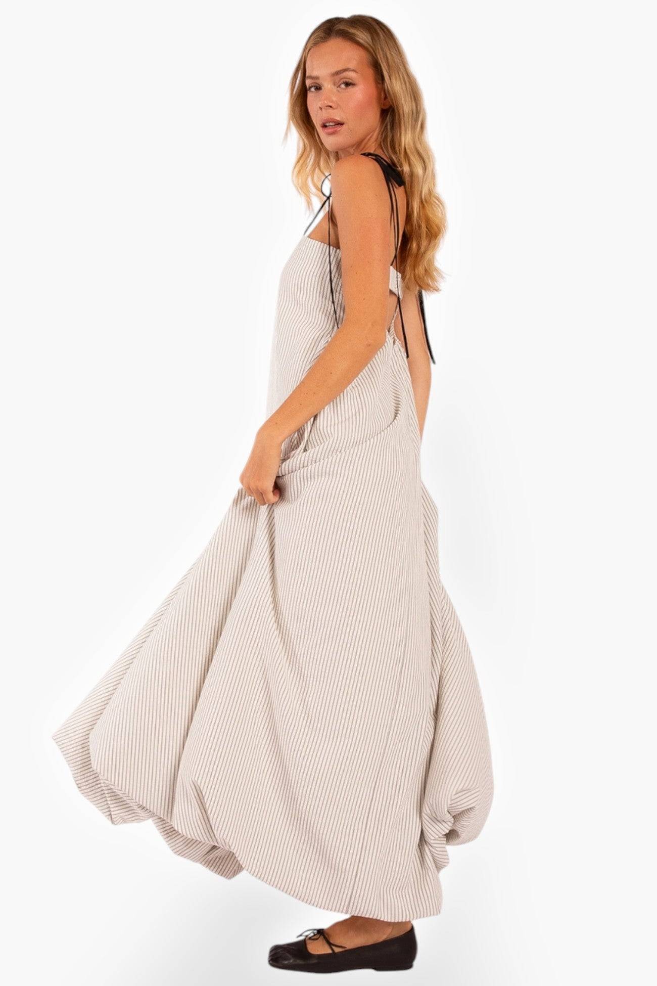Side view of Shoreline Striped Maxi Dress with a flowing bubble hem. The lightweight fabric and relaxed fit make it ideal for resort wear.